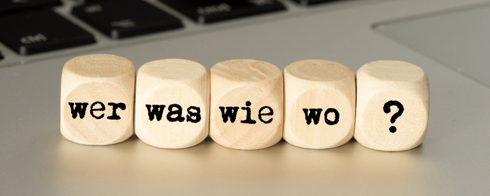 5 Würfel in Reihe mit den Begriffen wer was wie wo und einem Fragezeichen