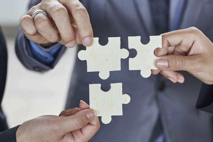 3 Personen halten in Ihren Händen drei Puzzelstücke zusammen. Per Klick gelangen Sie zur Seite Verantwortung und Organisation