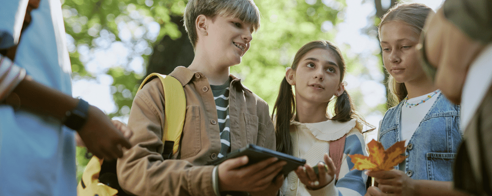 Schülerinnen und Schüler diskutieren während im Botanischen Garten über Pflanzen