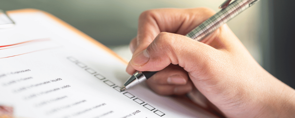 Eine Checkliste wird auf einem Klemmbrett bearbeitet