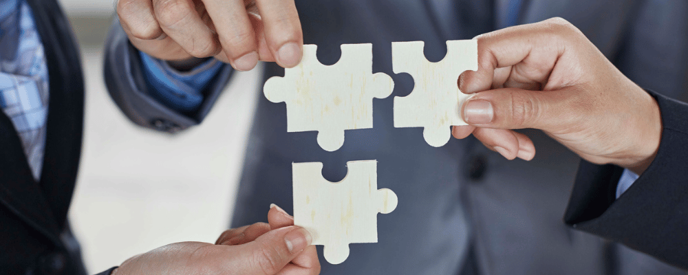 3 Hände, die 3 Puzzleteile halten