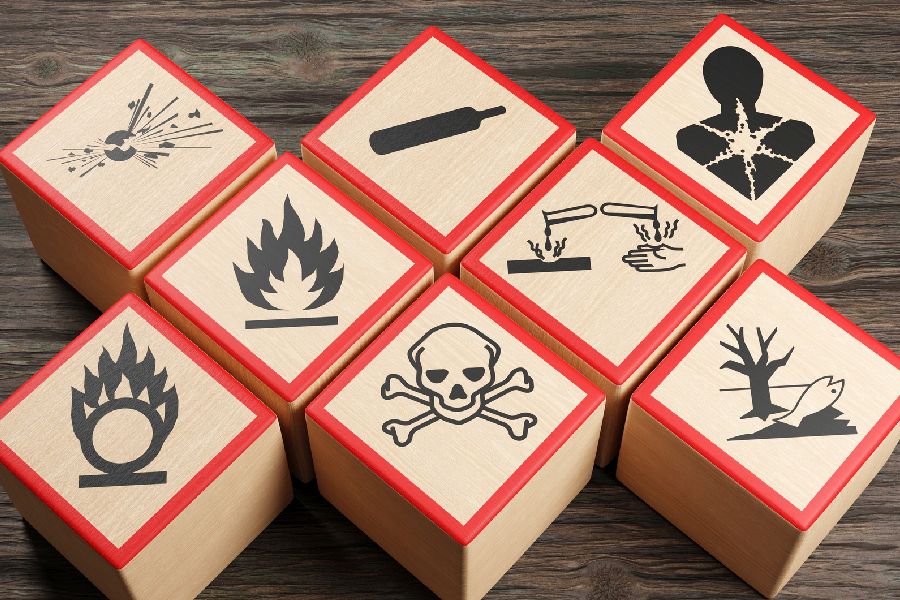 Holzklötze mit verschiedenen Symbolen chemischer Gefahrenwarnungen auf Holztisch Per Klick gelangen SIe zur Unterseite Gefahrstoffmangement
