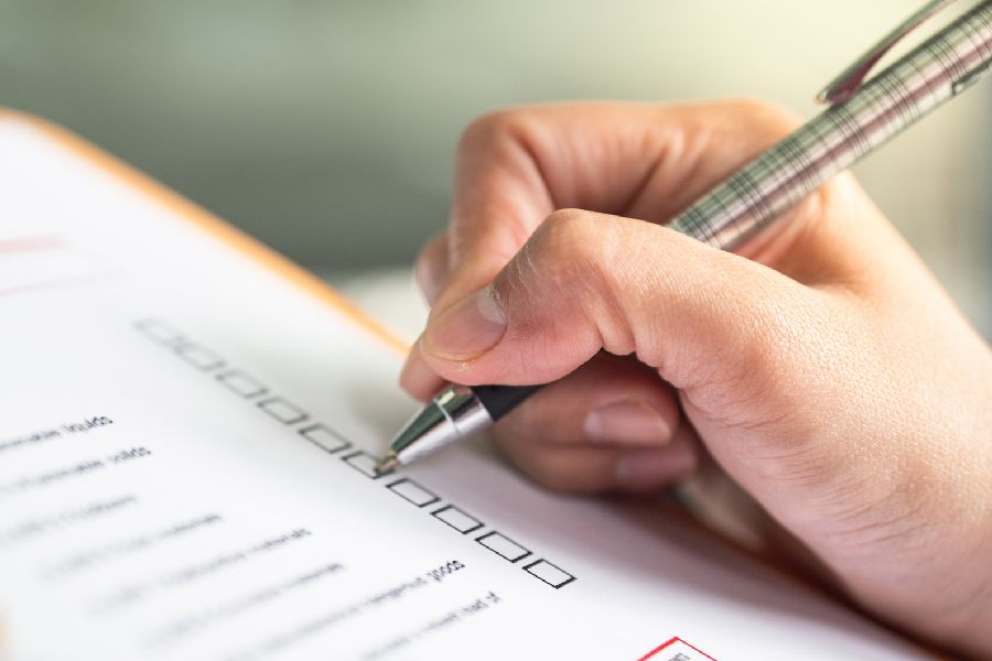 Eine Checkliste wird auf einem Klemmbrett bearbeitet Klick gelangen Si